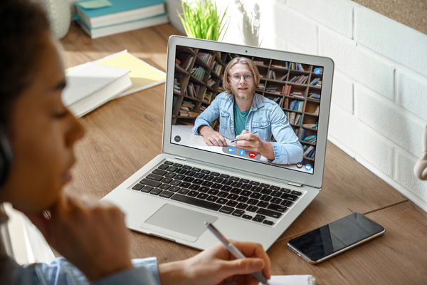 A student engaging in an online lesson with a tutor shown on screen